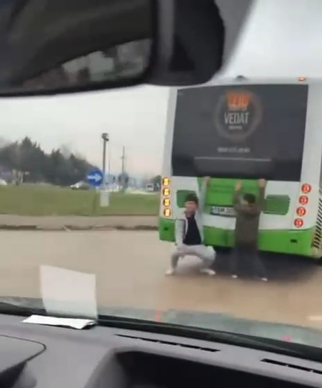 Bursa'da otobüsün arkasına tutunarak