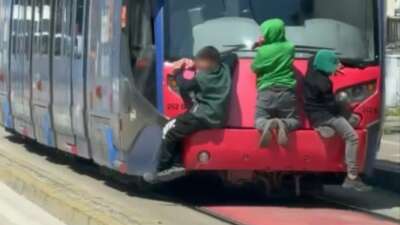 Bursa'da tramvayın arkasına tutunarak ilerleyen