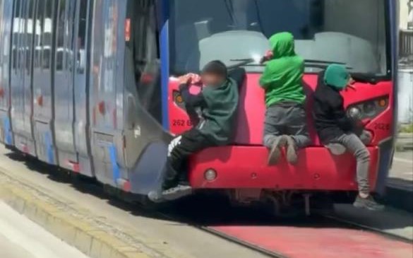 Bursa'da tramvayın arkasına tutunarak